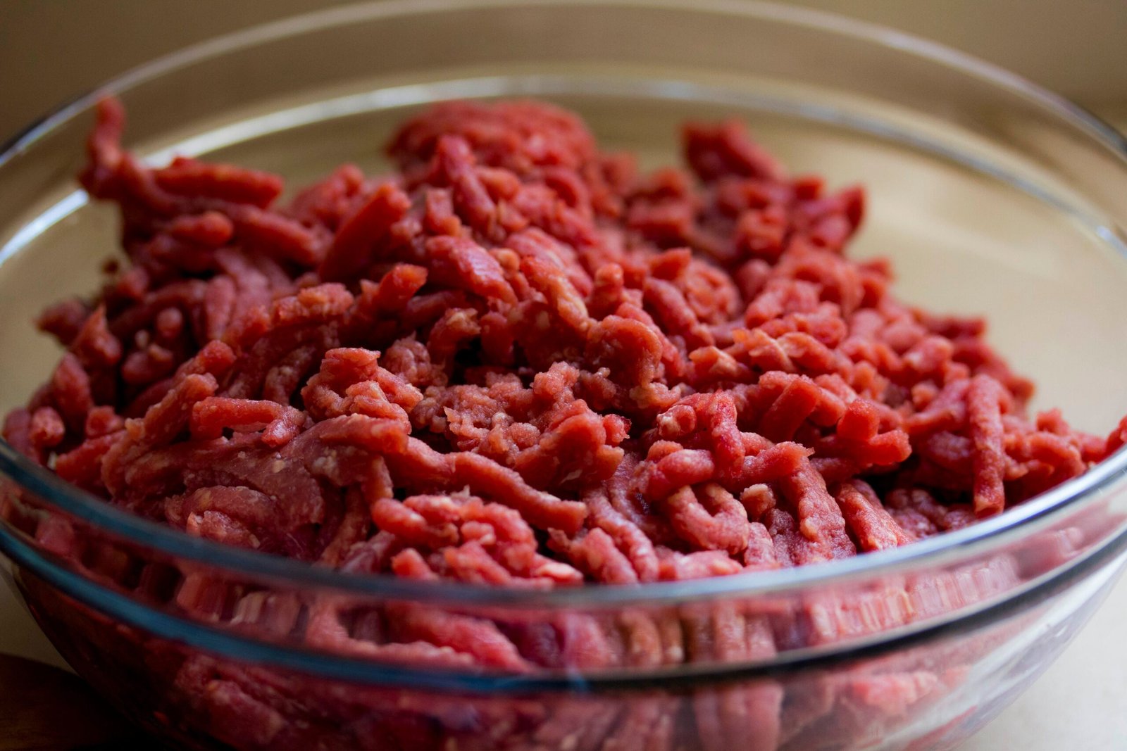 High-quality image of fresh ground beef in a glass bowl, ideal for culinary and food-related themes.